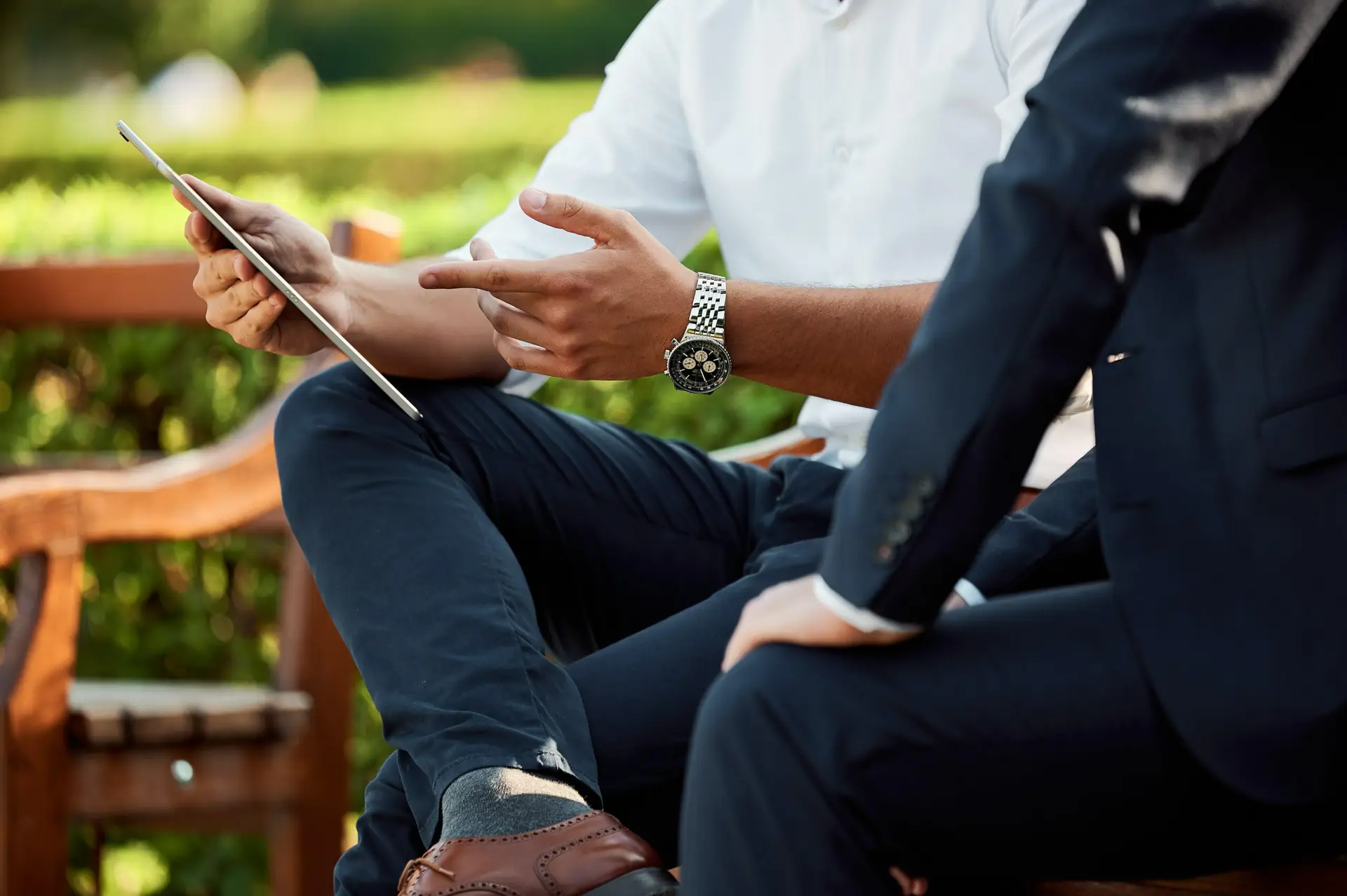 One man showing another a tablet in an outdoor setting