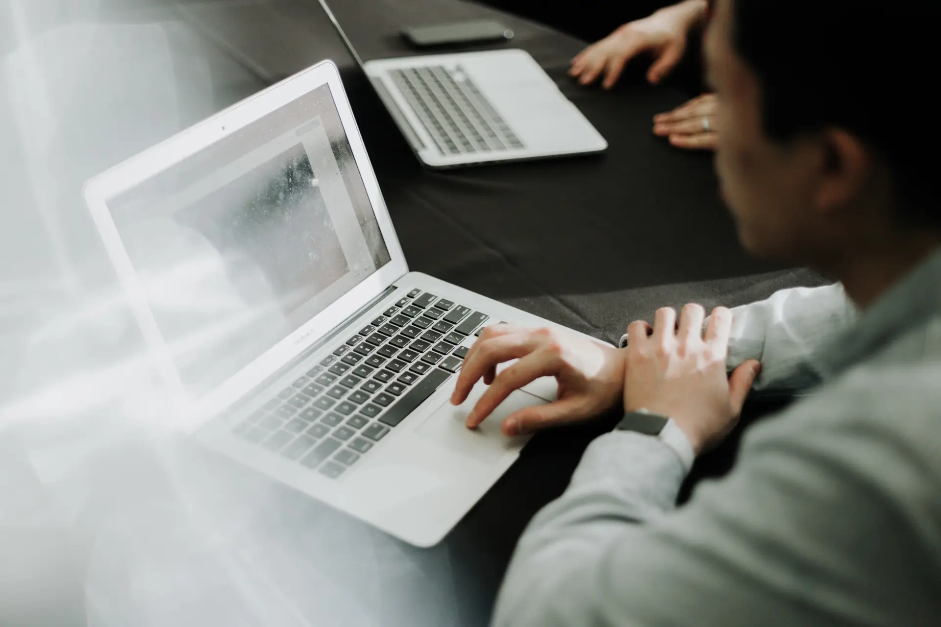 Man with his back to the camera looking at a laptop