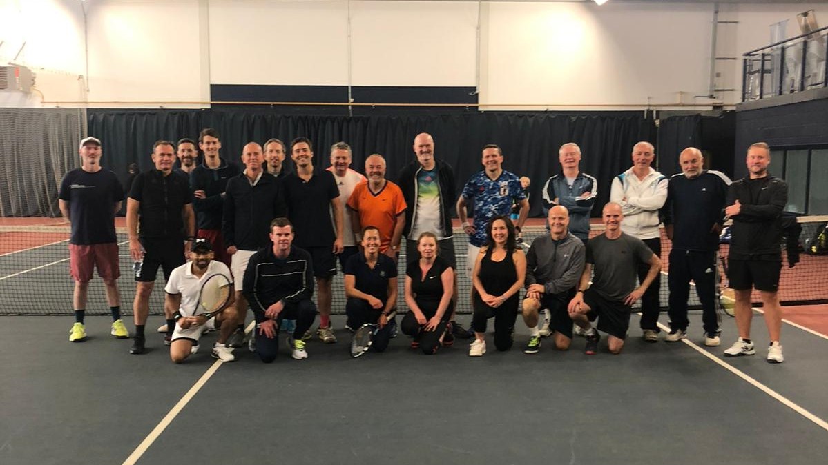 An image featuring all event participants in a group on a tennis court